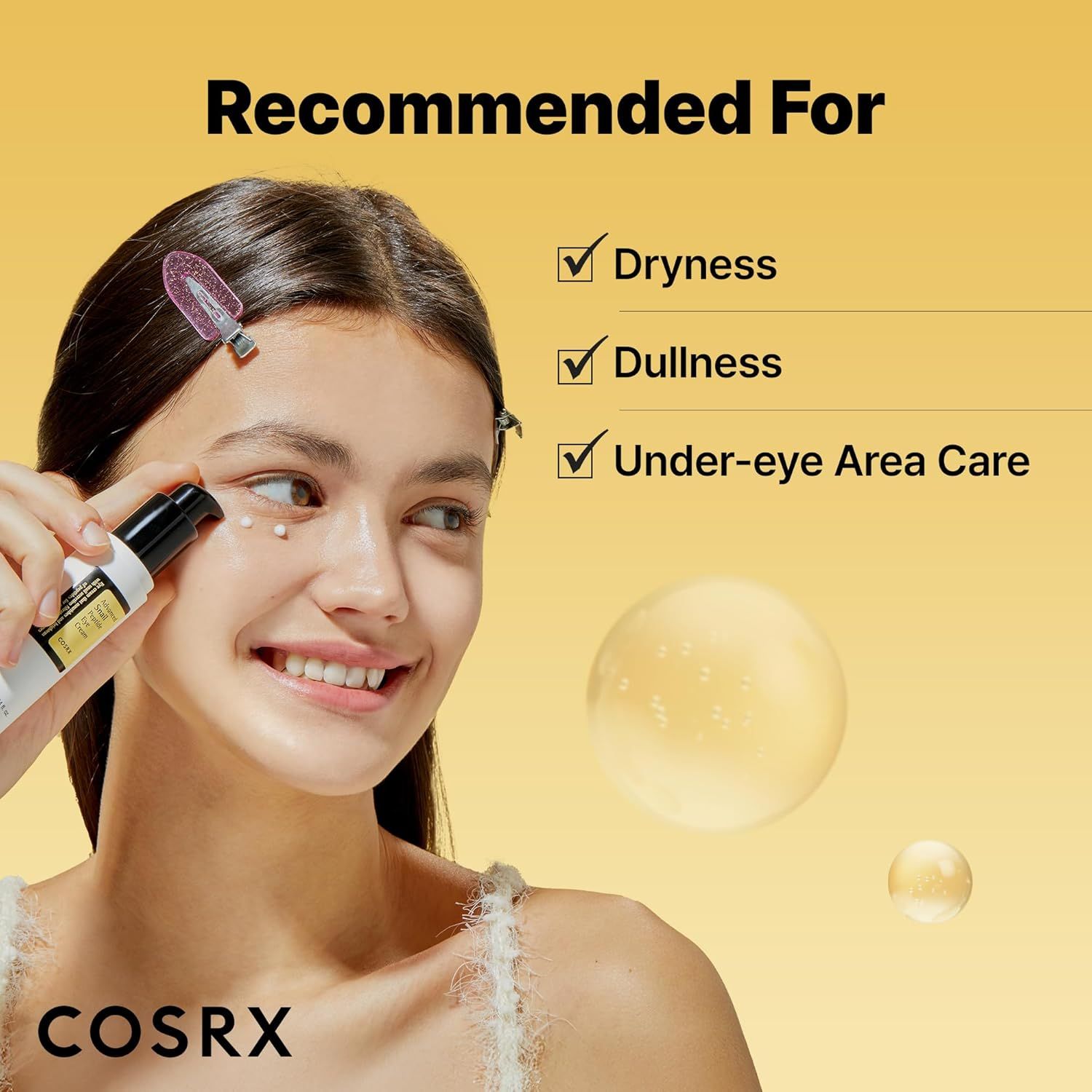Donna che applica la crema per gli occhi. Sfera gialla sullo sfondo. Testo: COSRX, Recommended For: Dryness, Dullness, Under-eye Area Care.