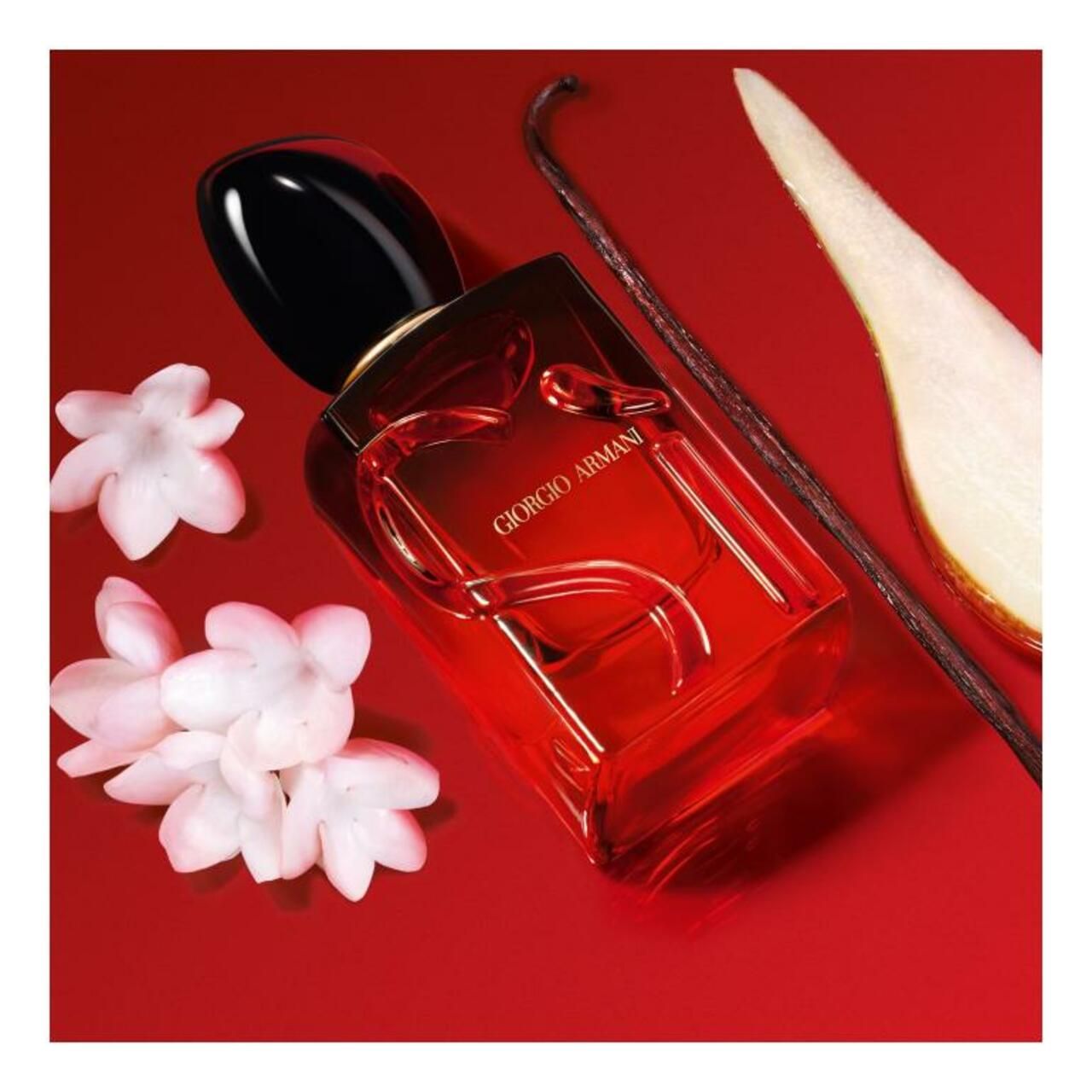 Flacone rosso Giorgio Armani Sì Passione Intense Eau de Parfum. Tappo nero. Con fiori di gelsomino, baccello di vaniglia e pera.