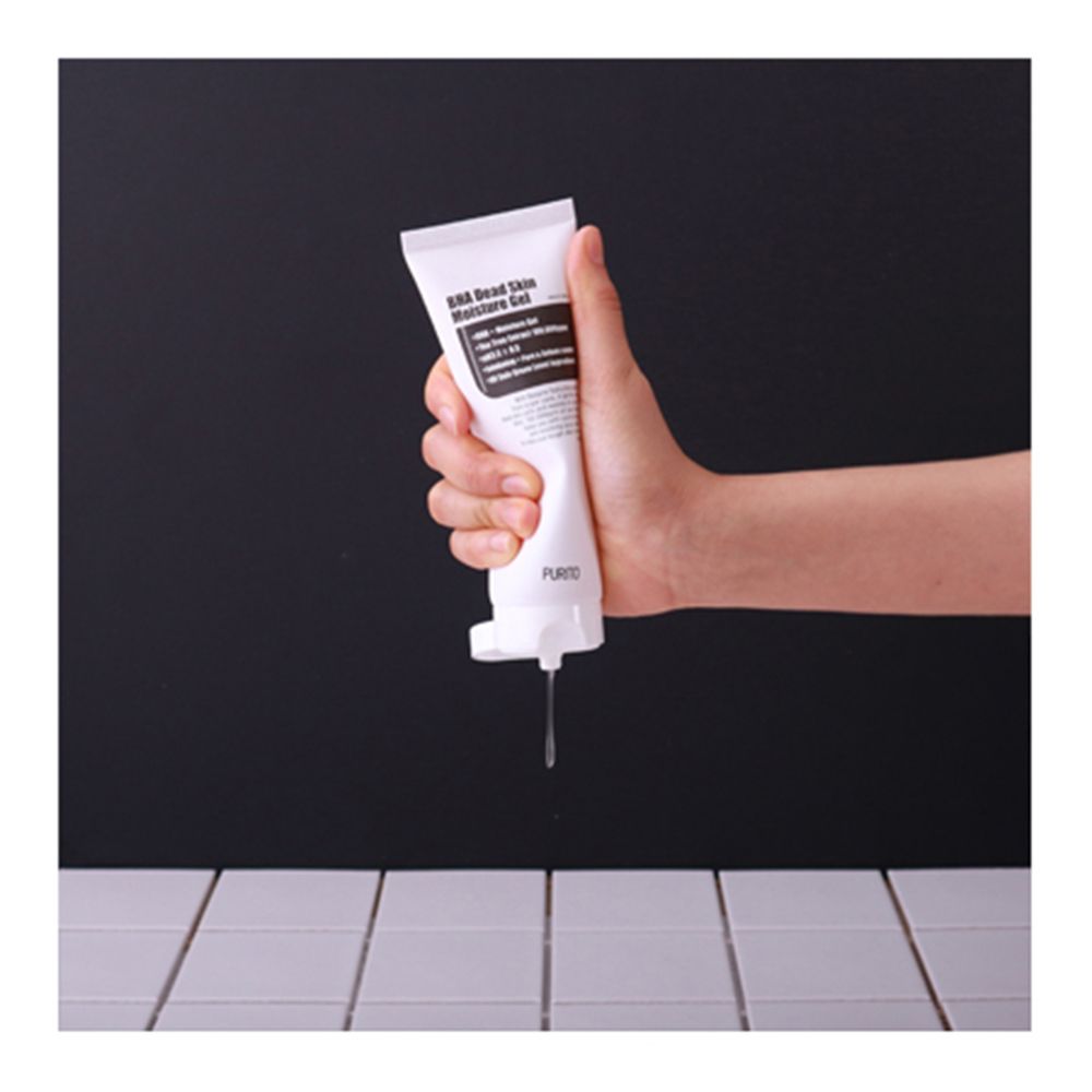 Tubo bianco con etichetta nera, PURITO. Prodotto tenuto in mano, gel che cola.