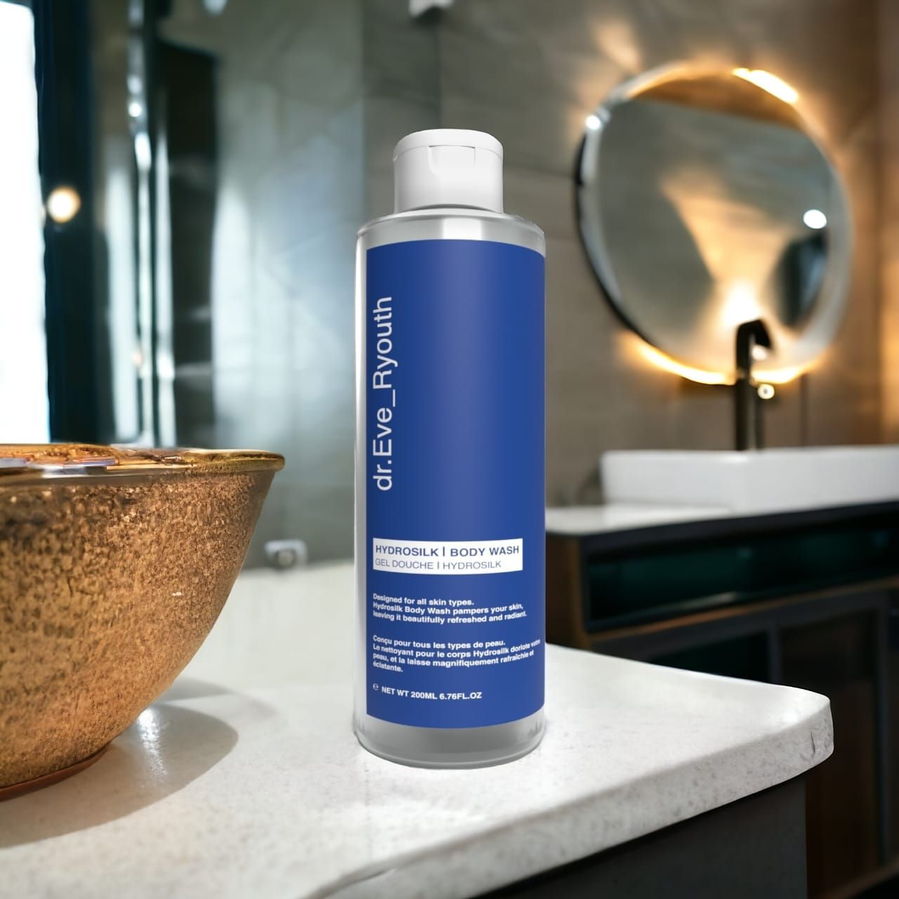 Flacone trasparente con etichetta blu. Scritta: dr.Eve_Ryouth, Hydrosilk Body Wash. Scena bagno con specchio e lavabo sullo sfondo.