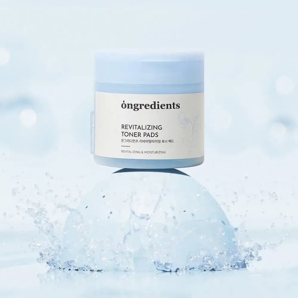 Barattolo blu e bianco "öngredients" con "Revitalizing Toner Pads". Spruzzi d'acqua.