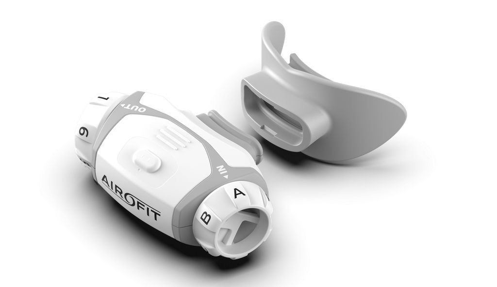 Allenatore respiratorio bianco-grigio, boccaglio e manopole. Scritte: Airofit, IN, OUT, numeri e lettere.