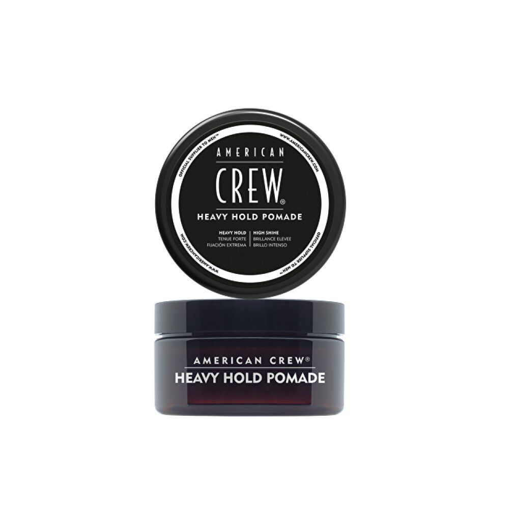 Due barattoli neri di American Crew Heavy Hold Pomade. Il coperchio superiore mostra il nome e i dettagli del prodotto. Il barattolo inferiore è aperto.
