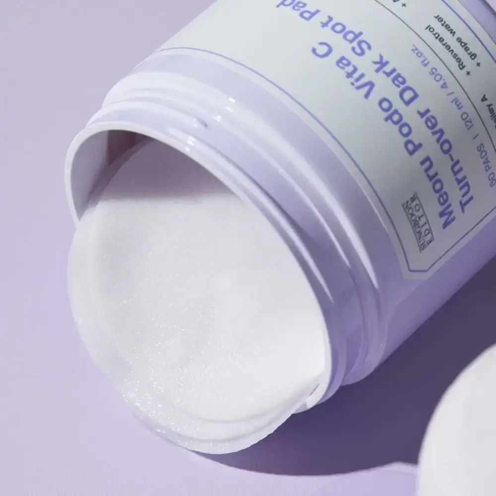 Barattolo aperto con pads. Scritta: Meoru Podo Vita C Turn-over Dark Spot Pad. Pads visibili.