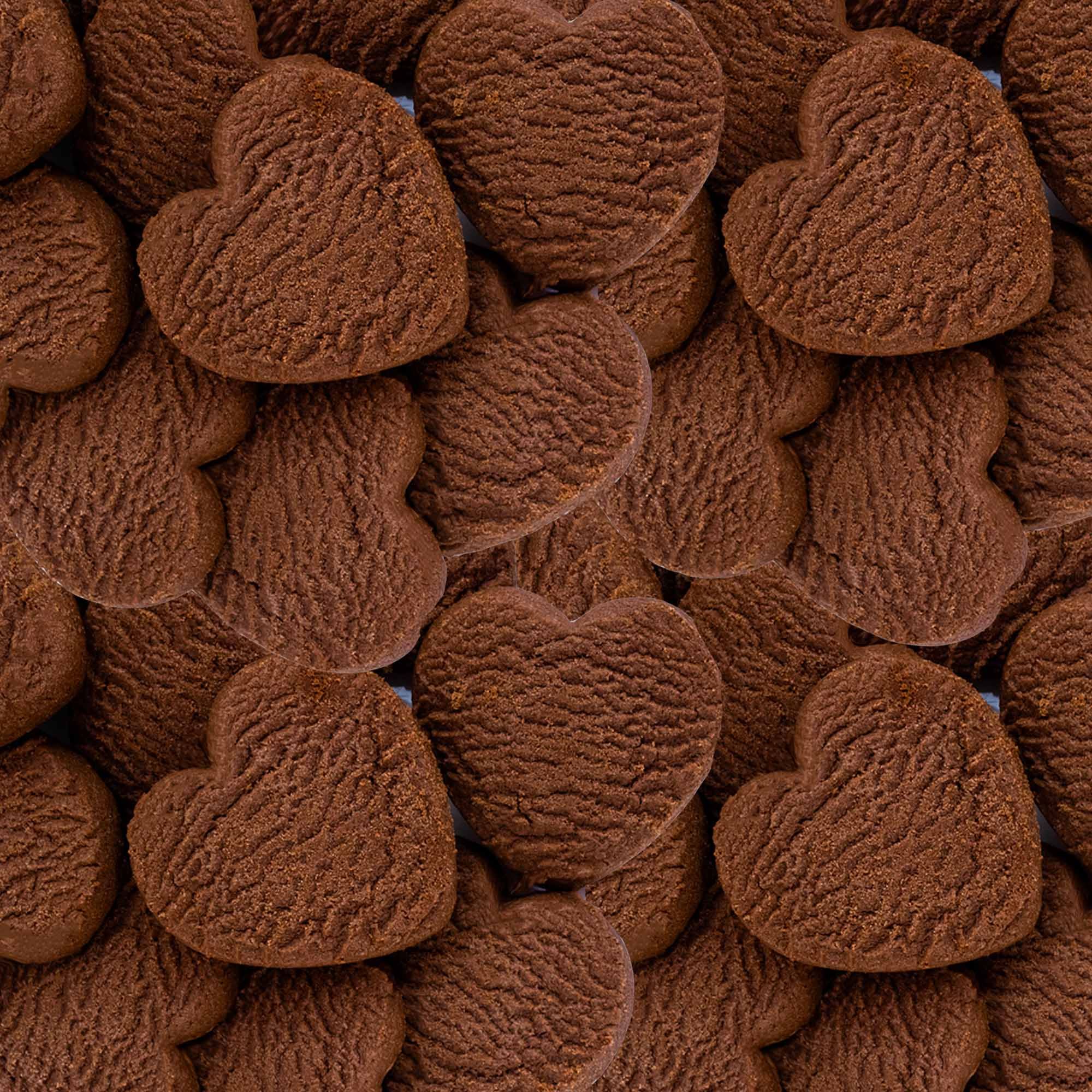 Primo piano di molti biscotti IoBoscoVivo senza glutine a forma di cuore.