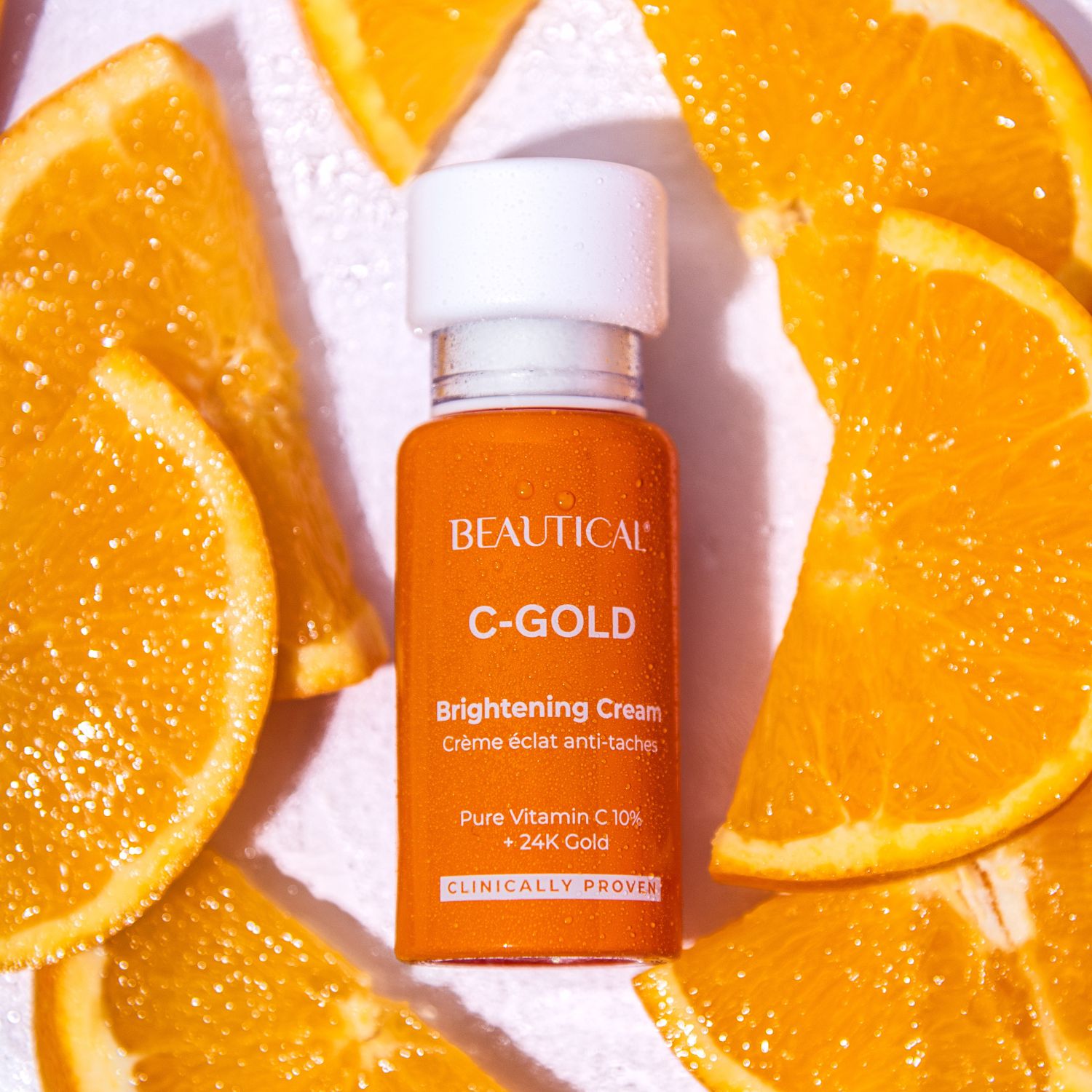 Flacone e fette d'arancia. Scritta: BEAUTICAL C-GOLD Brightening Cream.