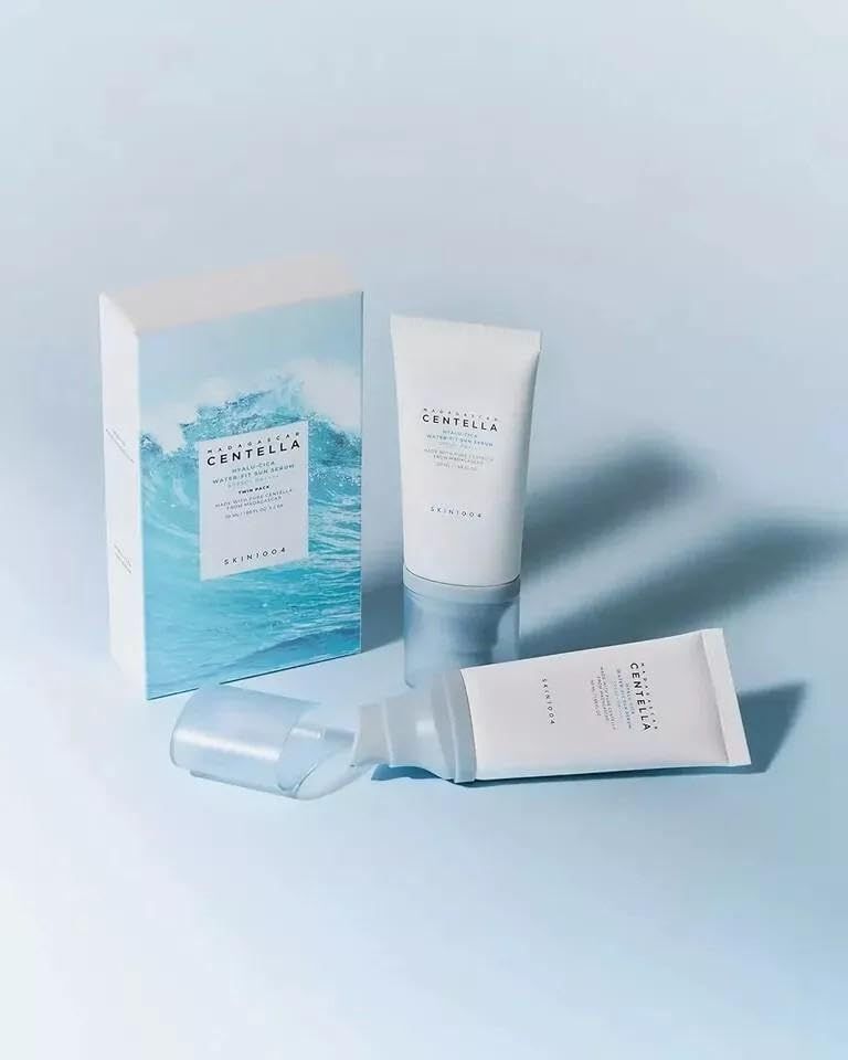 Due tubi e una scatola. Scritta: Centella Hyalu-Cica Water-Fit Sun Serum. Marchio: SKIN1004. Confezione blu e bianca.