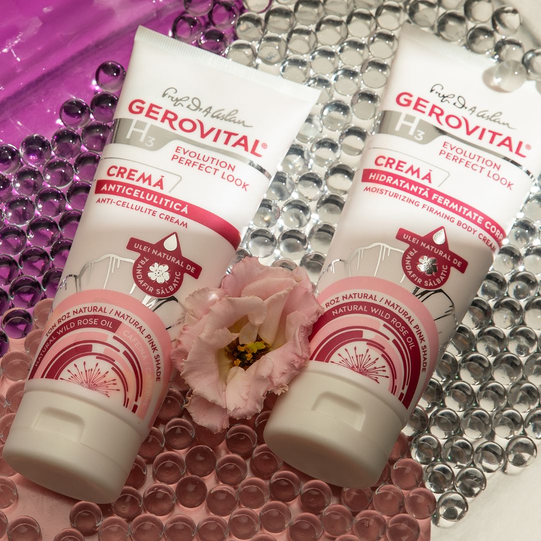 Due tubi di crema Gerovital. Etichette rosa e bianche. Su perle rosa e fiore.