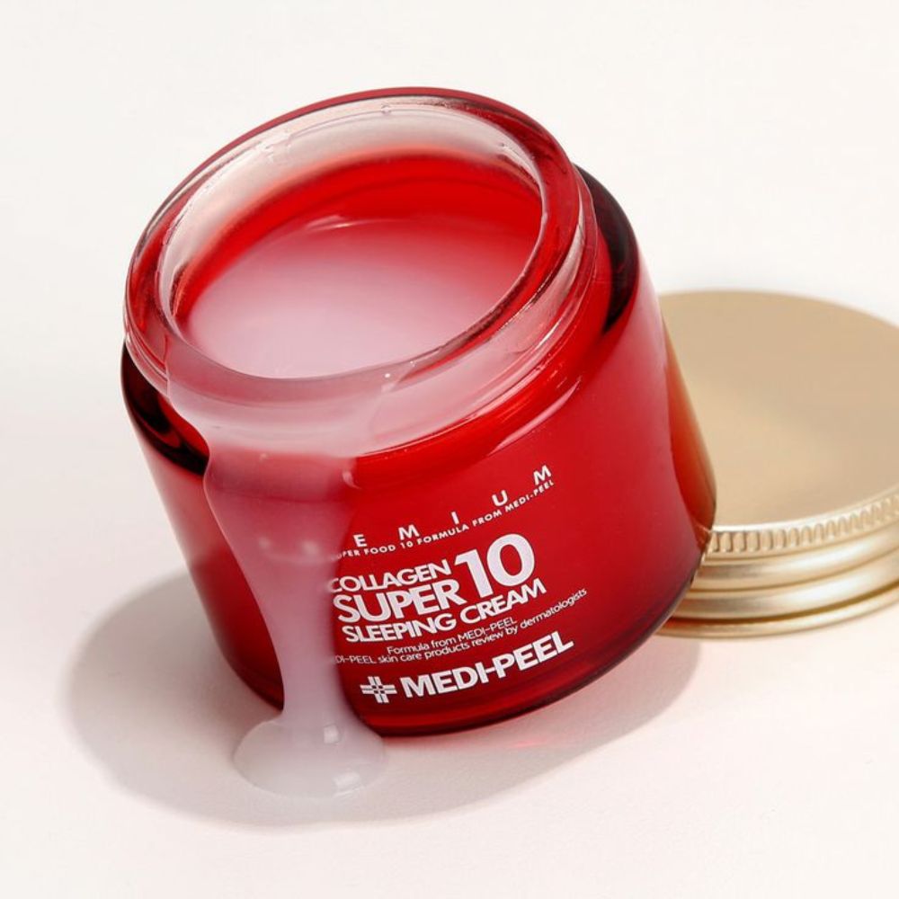Vasetto di crema in vetro rosso aperto con coperchio dorato, mostra crema bianca che cola dal bordo.