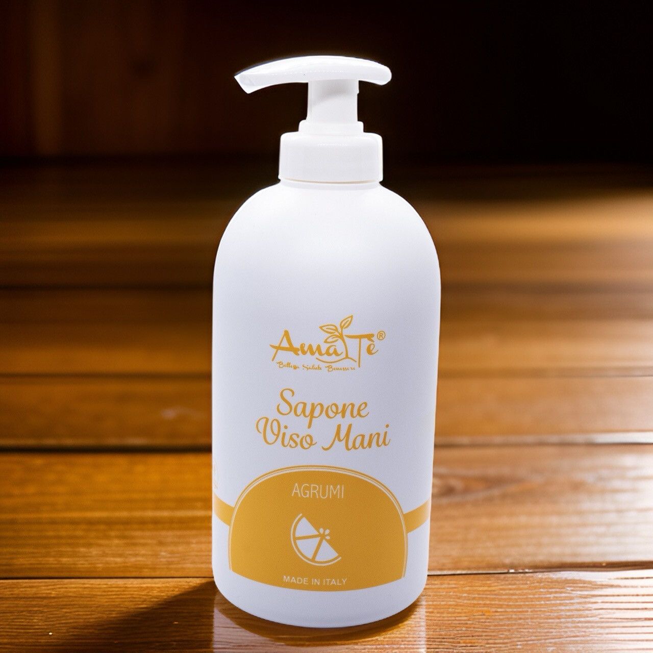 Flacone bianco con dosatore. Scritta: Amatè, Sapone Viso Mani, Agrumi. Etichetta gialla con simbolo di limone. Made in Italy.