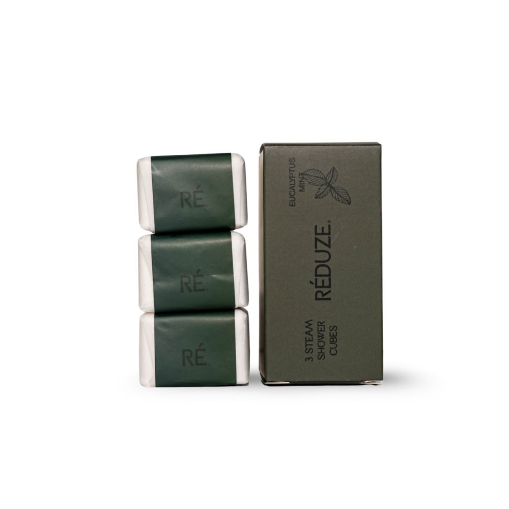 Tre cubi doccia e una scatola verde con logo "RÉDUZE". Testo: "EUCALYPTUS MINT" e "3 STEAM SHOWER CUBES".