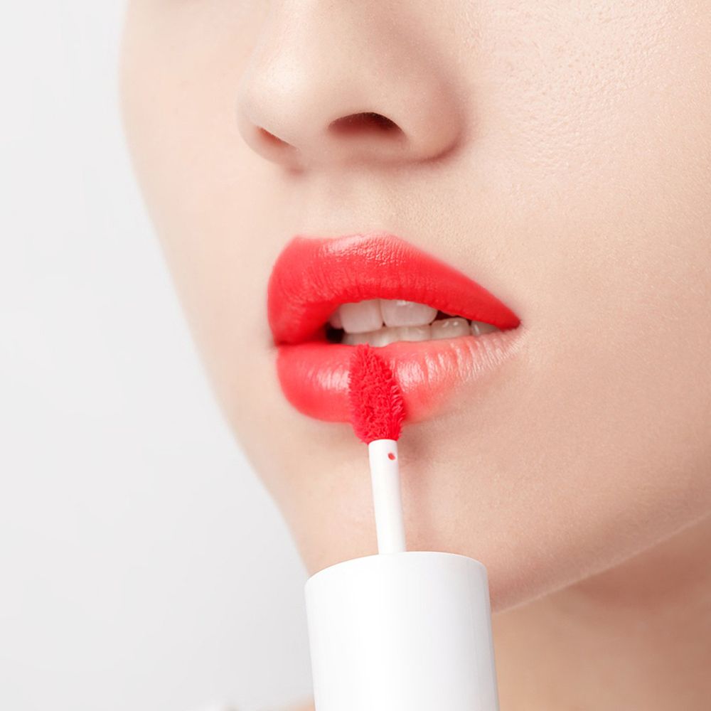 Labbra con tinta labbra rossa. Viene utilizzato un applicatore. La tinta è rossa e lucida.