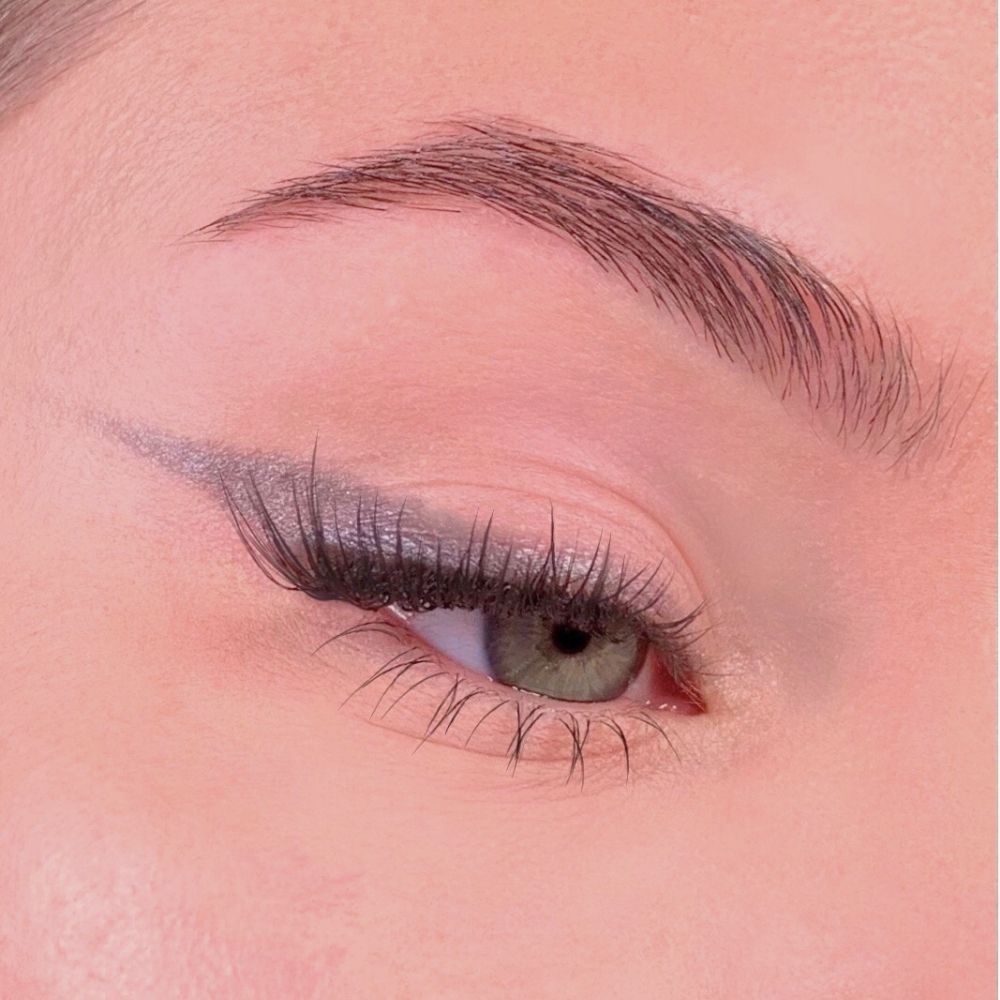 Occhio con eyeliner grigio. Ciglia e sopracciglia. Tono della pelle rosa.