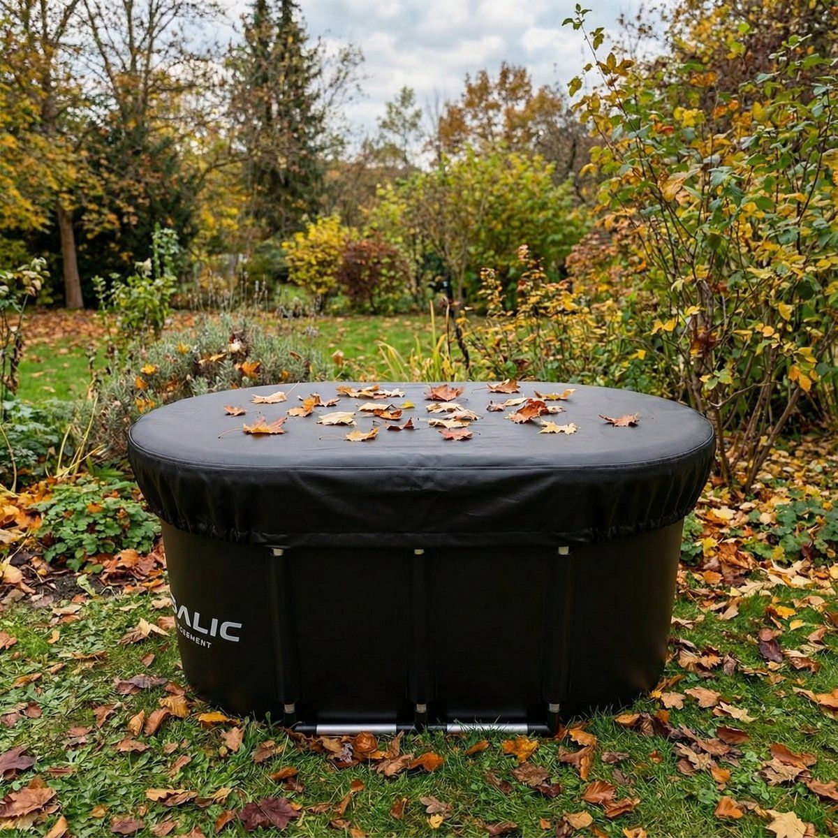 Vaschetta per ghiaccio nera con coperchio, ricoperta di foglie. Sul prato. Ambiente autunnale.