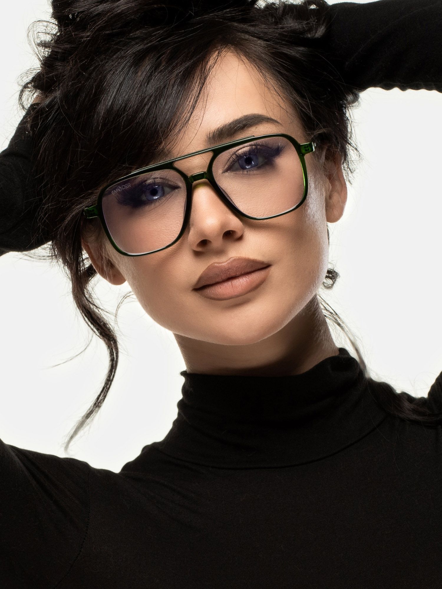 Donna con occhiali verdi con lenti quadrate. Doppio ponte, aste nere. Occhiali sul viso.