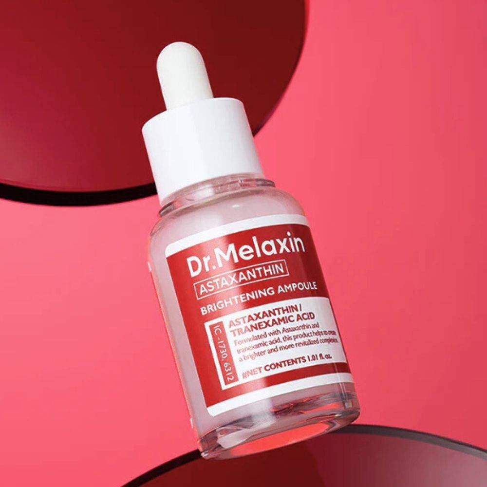 Flacone di vetro trasparente con tappo bianco ed etichetta rossa. Testo: Dr. Melaxin, Astaxantina, Brightening Ampoule. Contagocce.