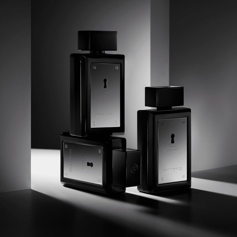 Tre flaconi di Antonio Banderas The Secret Eau de Toilette. Flaconi neri con placche argentate e design a buco della serratura.
