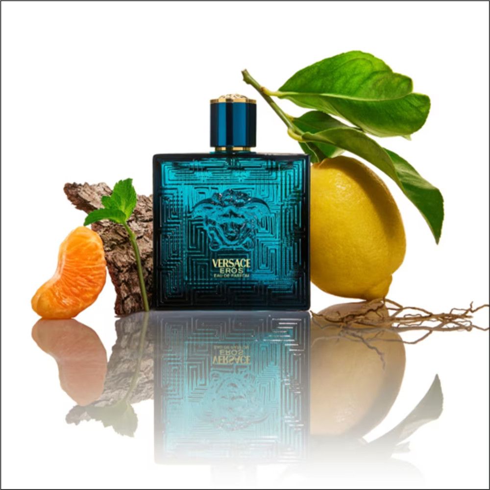 Flacone turchese con tappo dorato. Scritta: Versace Eros Eau de Parfum. Con frutta e rami.