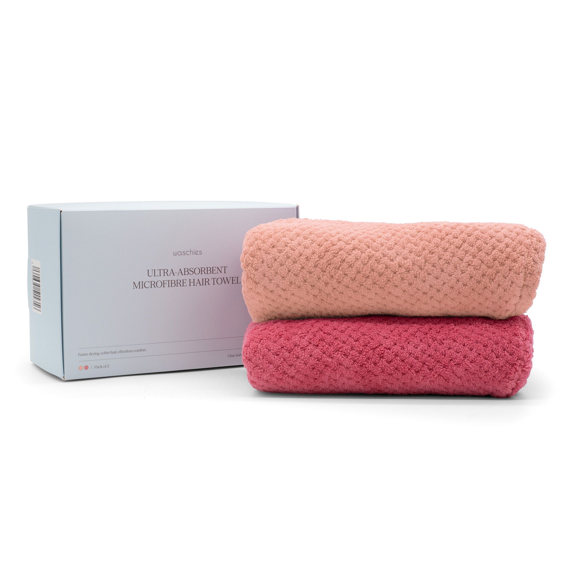 Due turbanti per capelli rosa arrotolati accanto a una scatola bianca. Testo sulla scatola: Ultra Absorbent Microfibre Hair Towel.