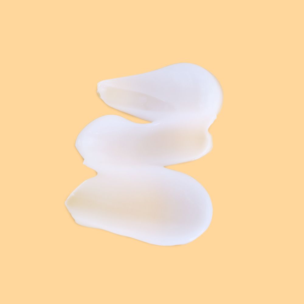 Tre strisce di crema bianca su sfondo beige. Le strisce sono disposte a forma di onda.