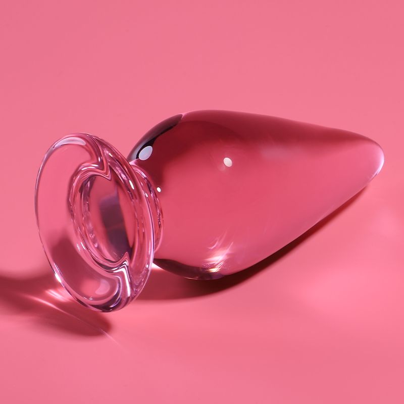 Plug anale in vetro rosa con base larga, lungo 11 cm, largo 5 cm.