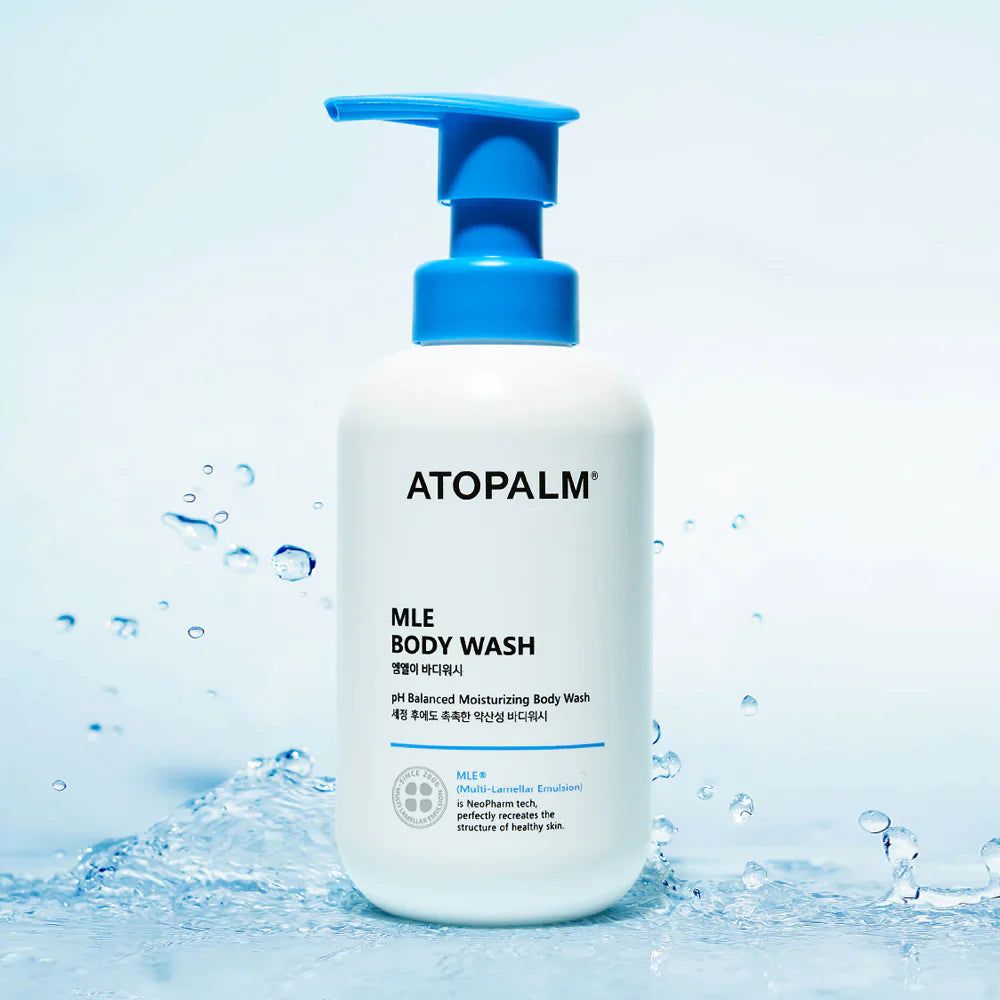 Flacone bianco con erogatore blu. Scritta: ATOPALM MLE BODY WASH. Sfondo d'acqua.