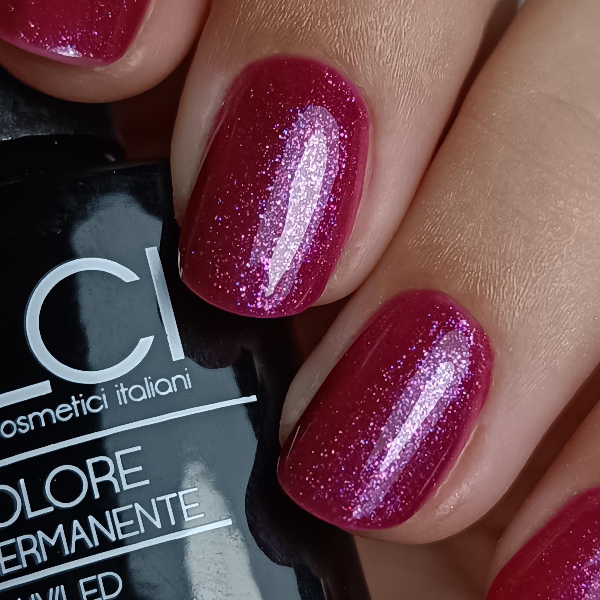 Primo piano di unghie smaltate. Colore: viola con glitter. Scritta: LCI, Colore Semipermanente, UVLED.