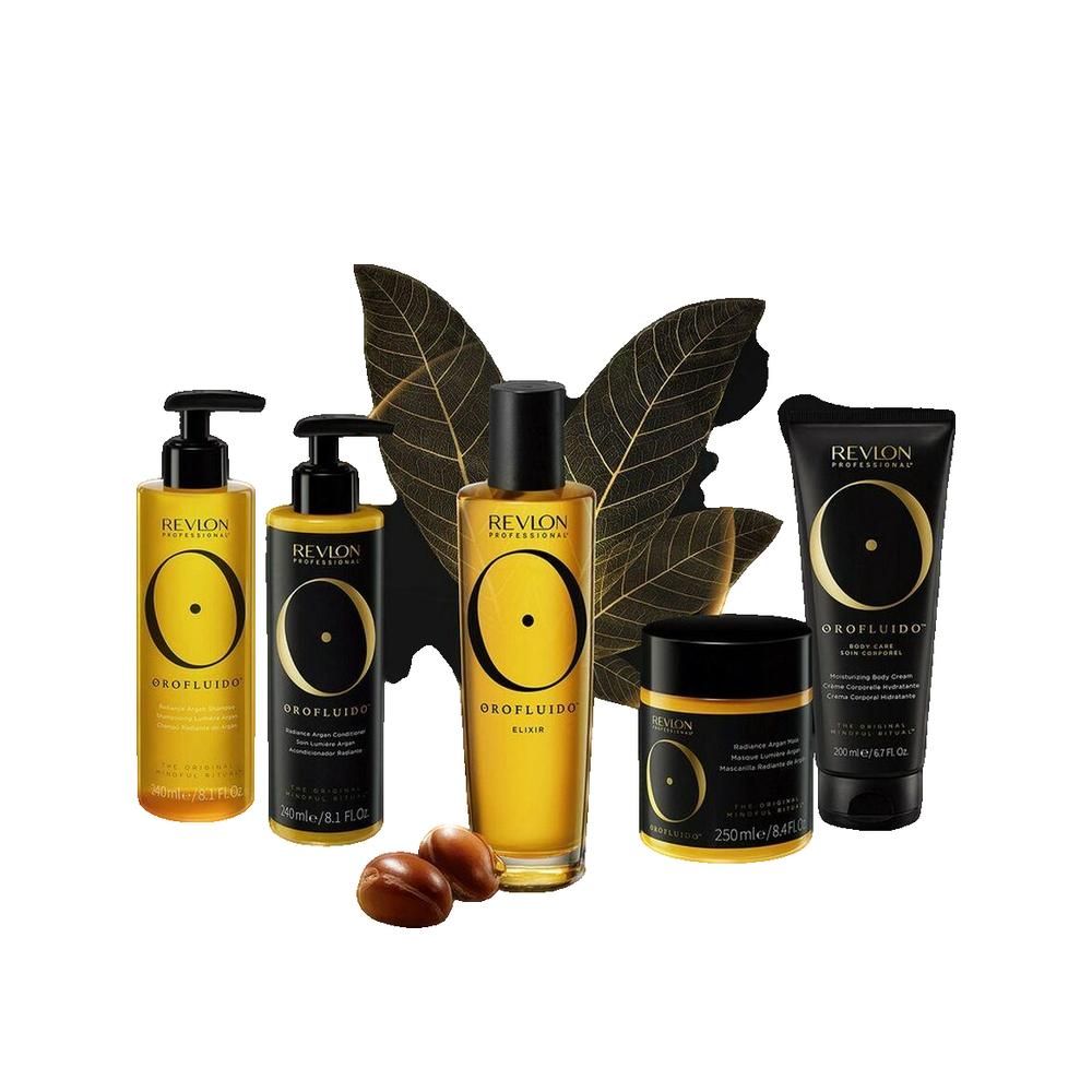 Vari prodotti Orofluido. Flaconi, vasi e tubetto in oro e nero. Semi di argan accanto.