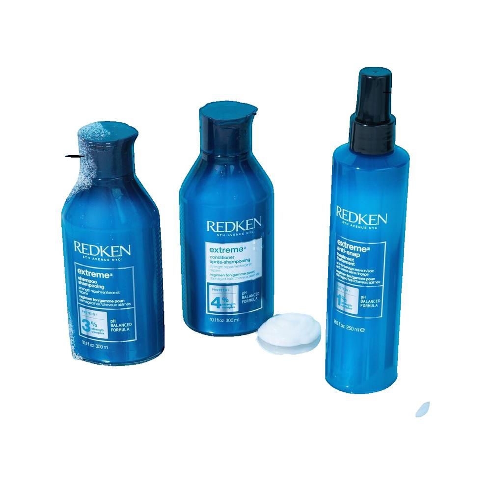 Tre bottiglie blu con tappi neri ed etichette. Una bottiglia ha un nebulizzatore. Un tampone bianco è accanto.