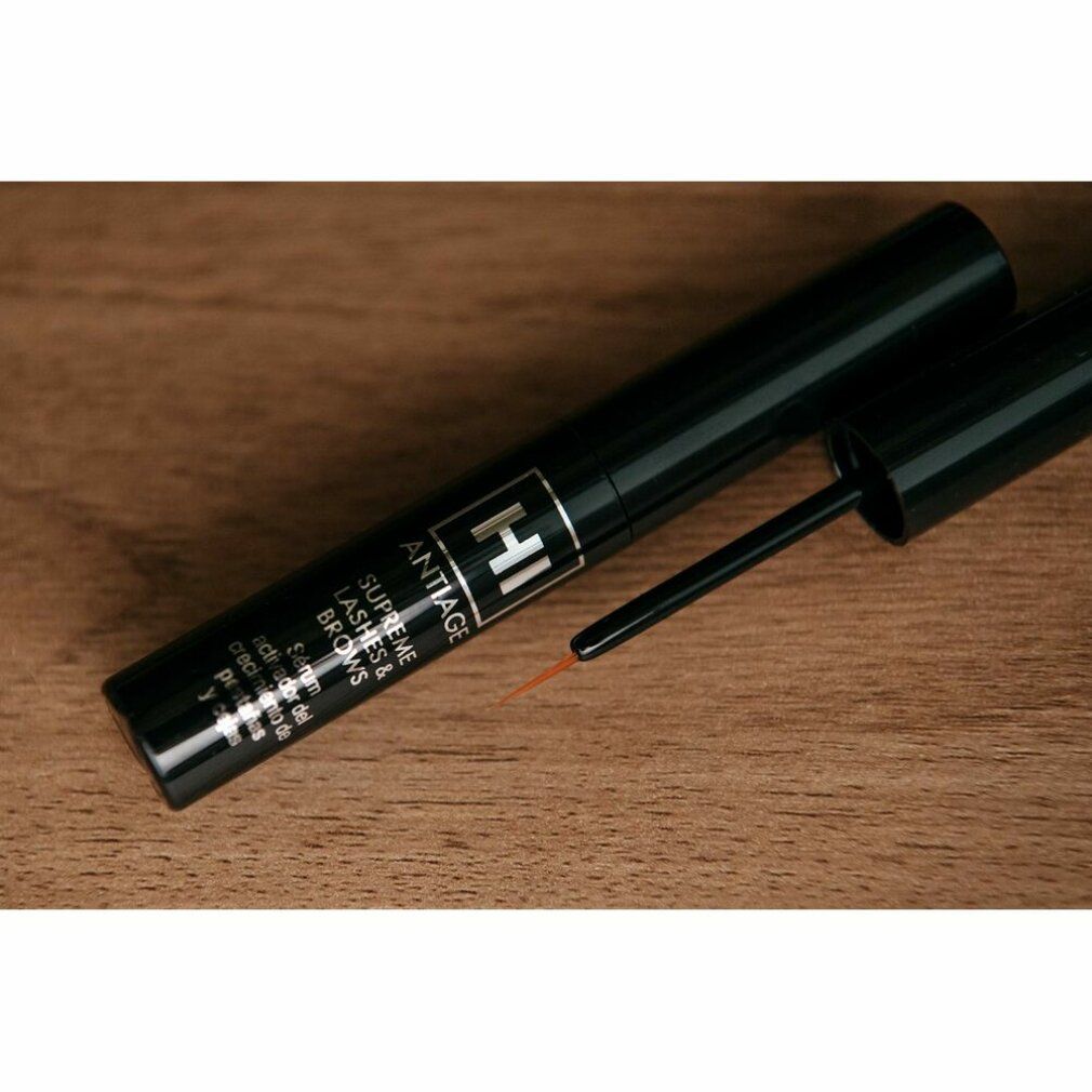 Tubo nero con applicatore. Scritta "HI ANTIAGE SUPREME LASHES & BROWS". Su sfondo legno.