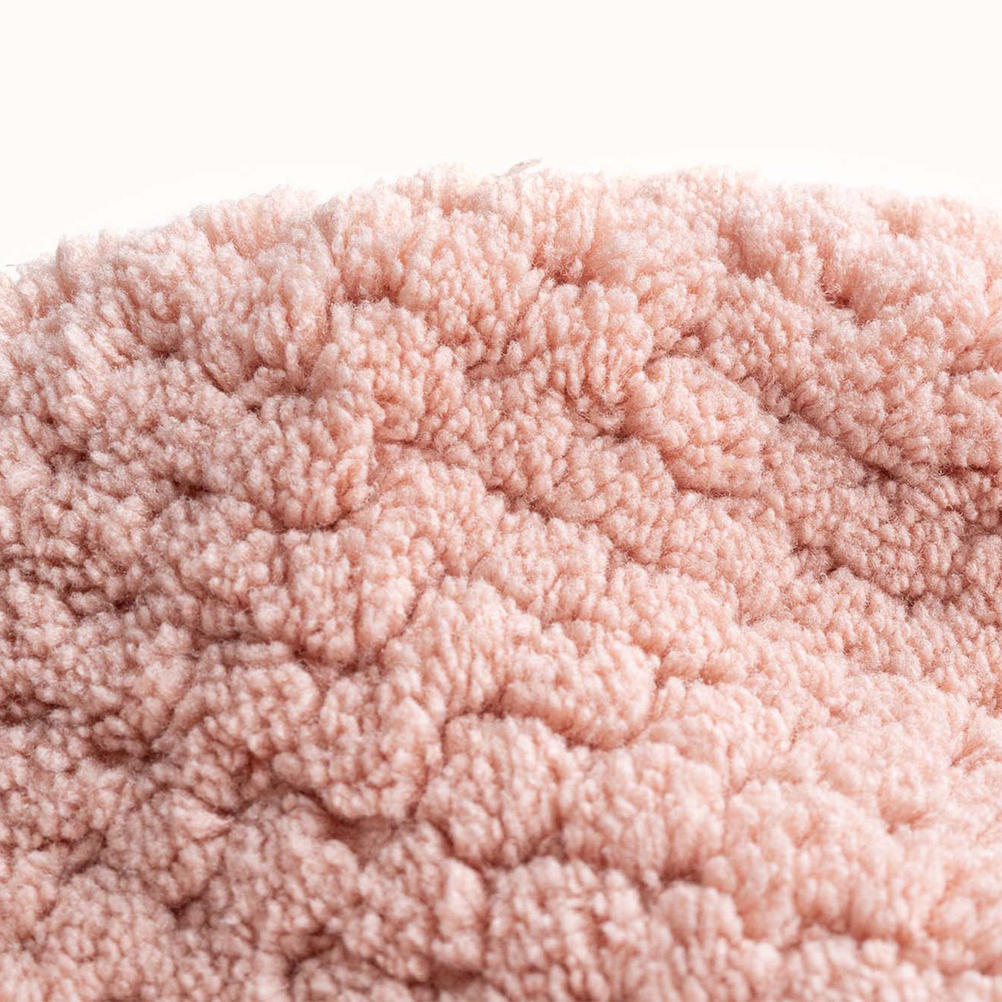 Primo piano di un turbante per capelli rosa. Superficie strutturata e morbida.