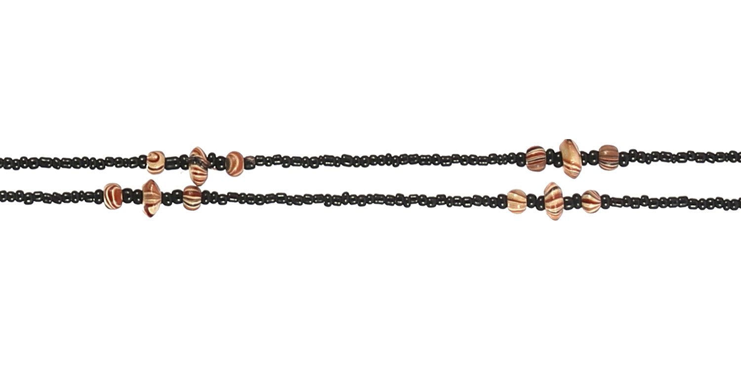 Primo piano di una catenina per occhiali. Catena di perline nere con dettagli marroni irregolari.
