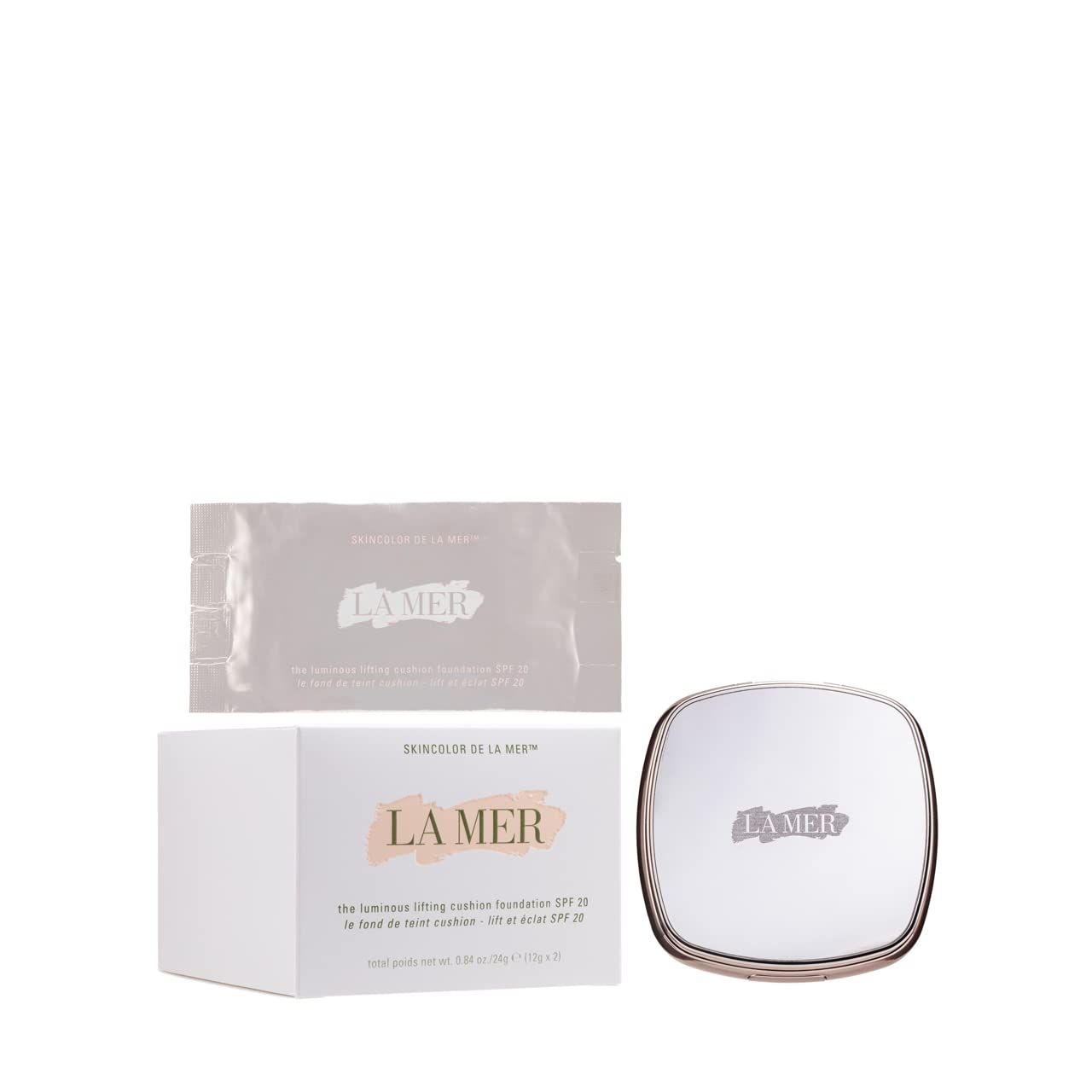 Trucco compatto, confezione e campione. Forma quadrata con angoli arrotondati. Marchio: La Mer. Testo sulla confezione.