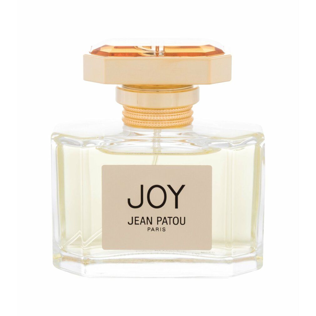Flacone di profumo con tappo dorato. L'etichetta riporta "JOY JEAN PATOU PARIS". Il flacone è rettangolare e trasparente.