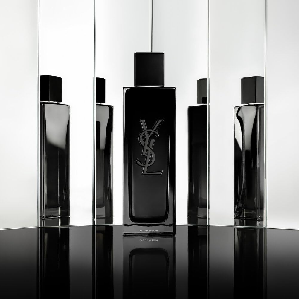 Diversi flaconi neri YSL Myslf Eau de Parfum davanti a specchi. Tappi neri, logo argentato.