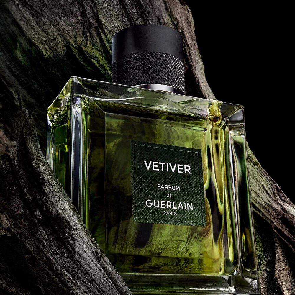 Flacone in vetro con liquido verdognolo. Tappo nero. Etichetta "VETIVER PARFUM de GUERLAIN PARIS".