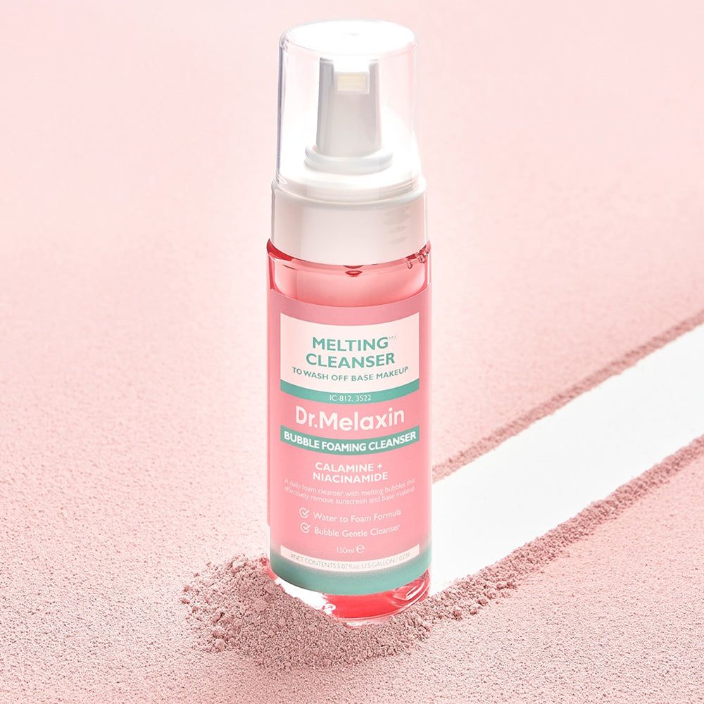 Flacone rosa con erogatore bianco. Scritta: Dr. Melaxin, Melting Cleanser, Bubble Foaming Cleanser. Su sfondo rosa.