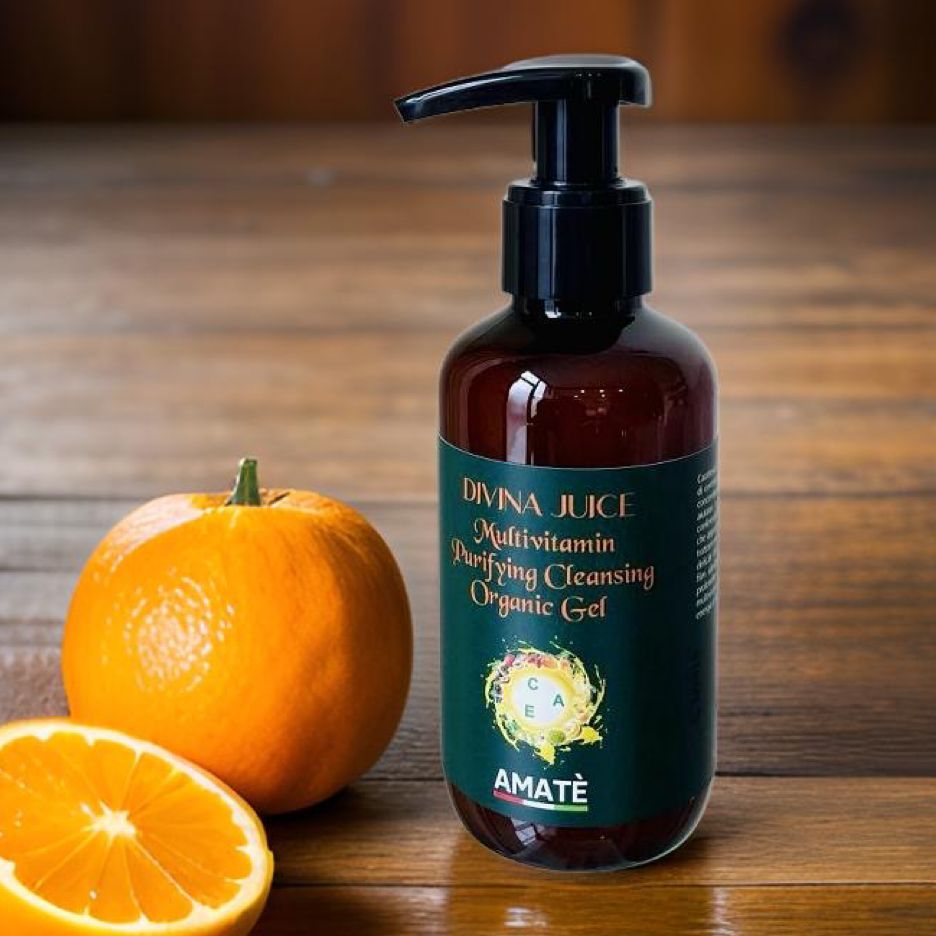 Flacone marrone con dosatore nero accanto a un'arancia. Scritta: DIVINA JUICE, Multivitamin, Purifying Cleansing Organic Gel. Marchio: AMATÈ.