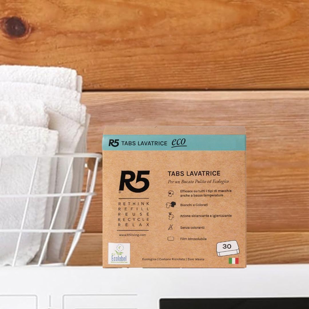 Confezione in cartone di pastiglie lavatrice accanto ad asciugamani. R5 Tabs Lavatrice Eco, logo Ecolabel, 30 pastiglie, Made in Italy.