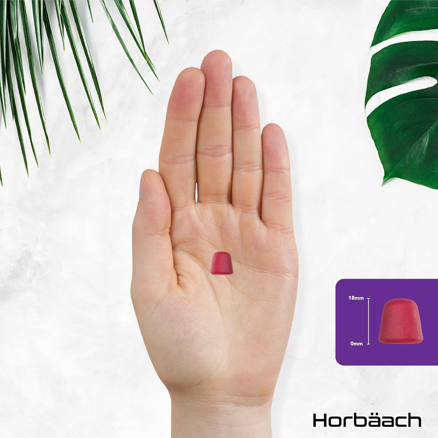 Orsetto gommoso rosso in mano. Dimensioni: 18mm x 9mm. Prodotto: Biotin Gummies.