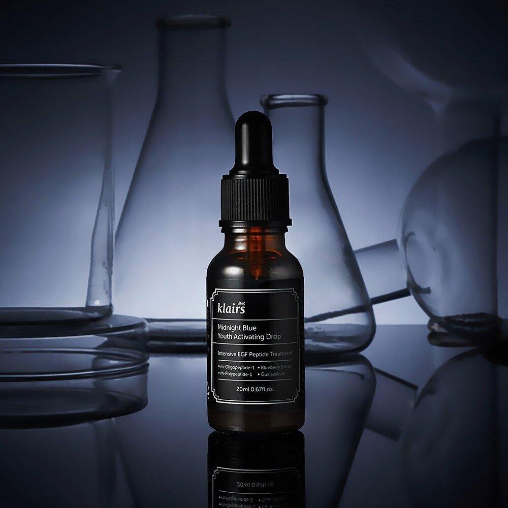 Flacone di vetro marrone con etichetta nera e contagocce. Bottiglia davanti agli utensili da laboratorio. Nome del prodotto e dettagli visibili.