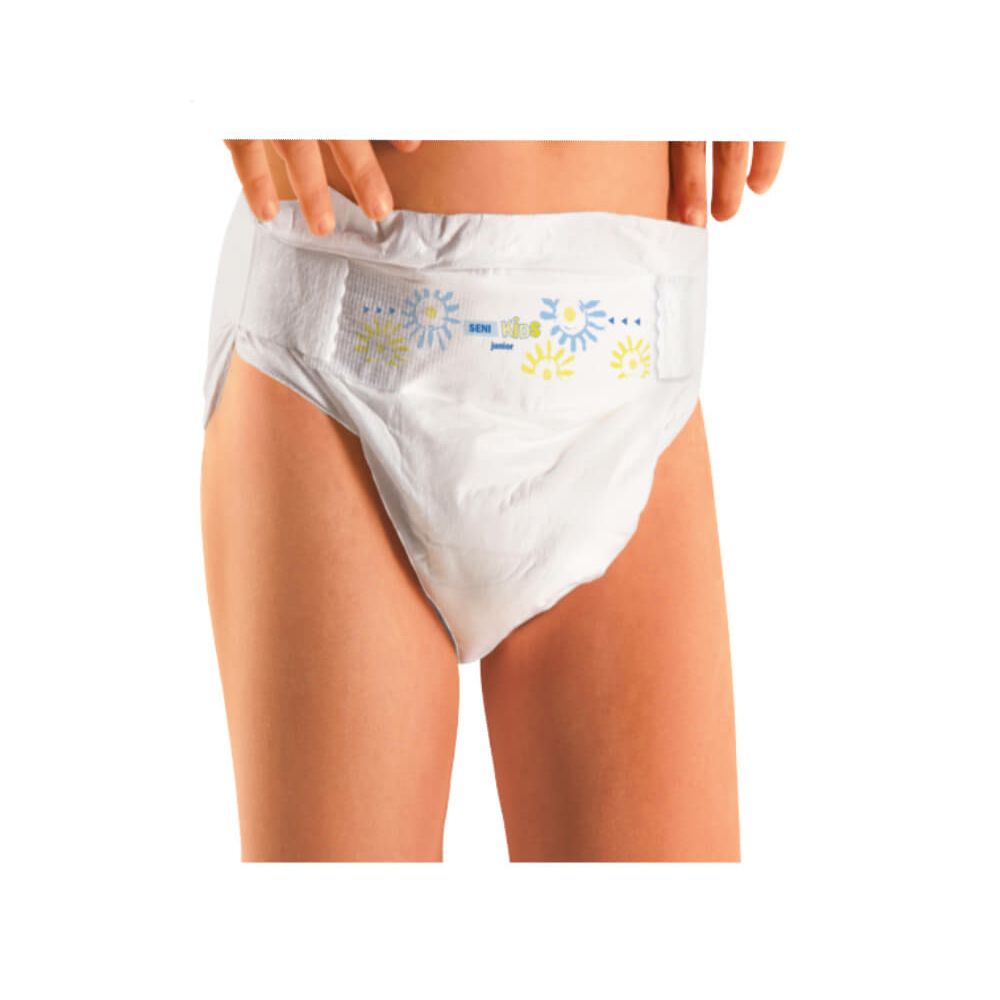 Bambino indossa un pannolino Seni Kids Junior. Motivi floreali blu e gialli. Il pannolino copre l'addome inferiore.