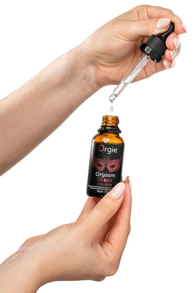 Mani che tengono il flacone Orgie Orgasm Drops Kissable, il contagocce gocciola.
