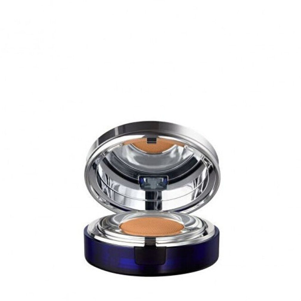 Fondotinta compatto aperto. Contenitore blu con coperchio argentato. Spugna e specchio visibili. Tonalità beige.