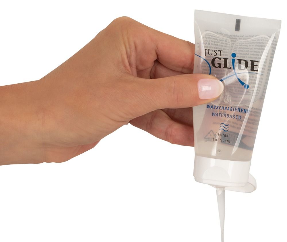 Mano che tiene un tubo di lubrificante Just Glide a base acquosa, il gel cola