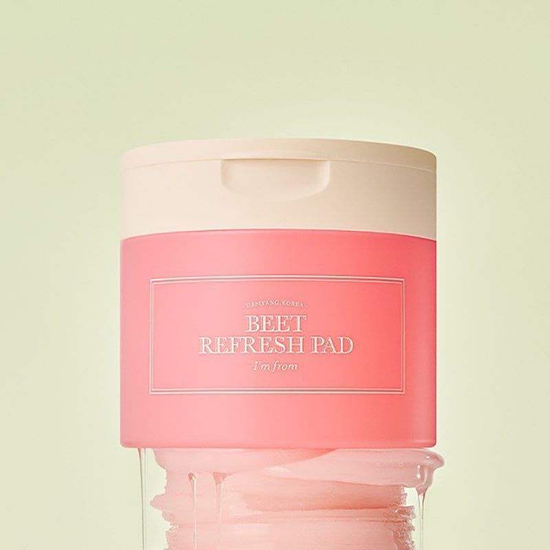 Barattolo rosa con coperchio bianco. Scritta: BEET REFRESH PAD, i'm from. Cuscinetti accanto.