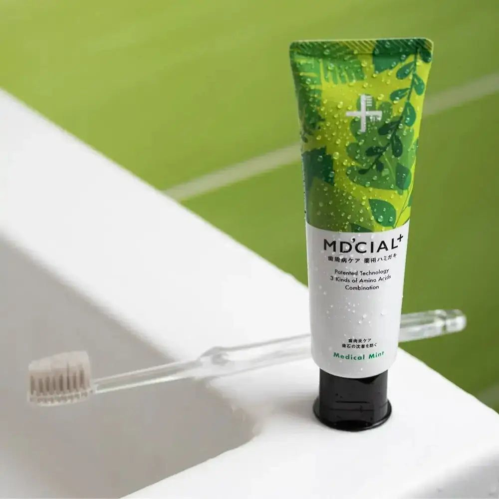 Tubo di dentifricio MD'CIAL+ verde e spazzolino. Scritta Medical Mint. Tappo nero.