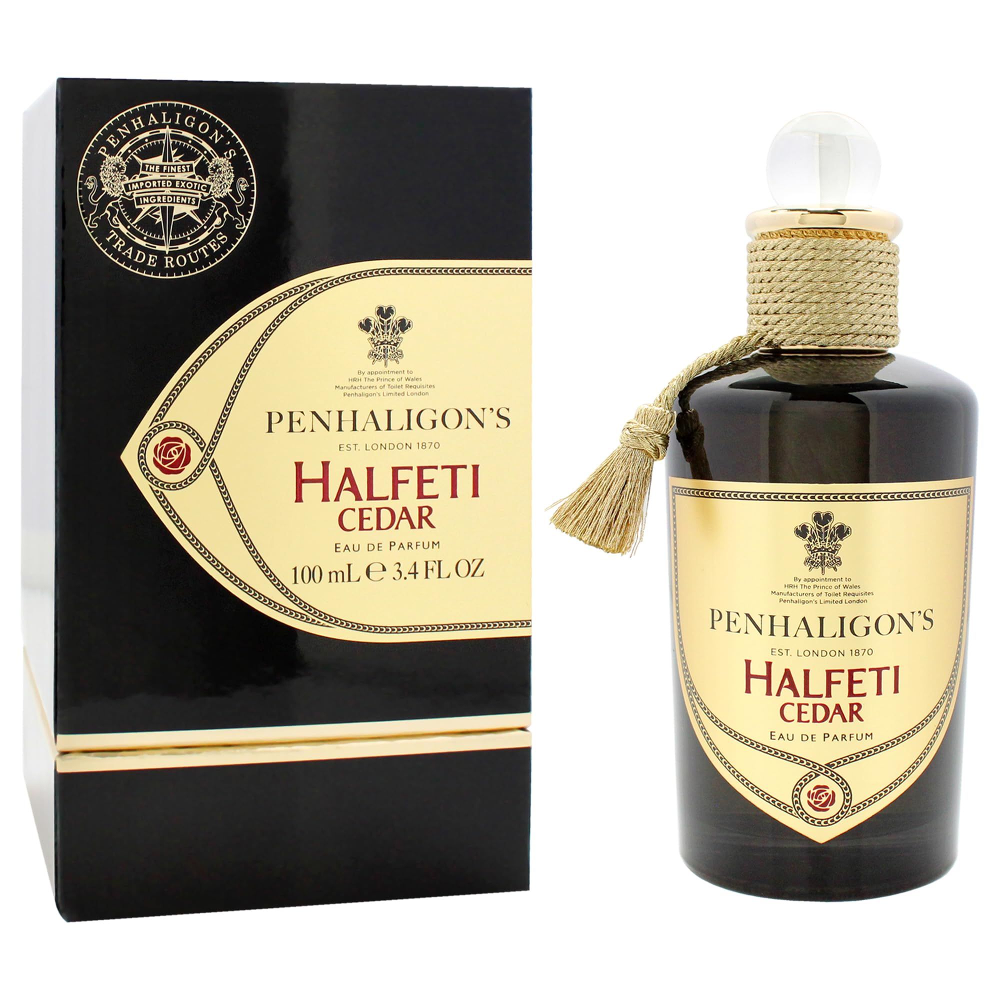 Flacone di profumo e confezione. Flacone con nappa e corda. Confezione nera con dettagli dorati e testo.