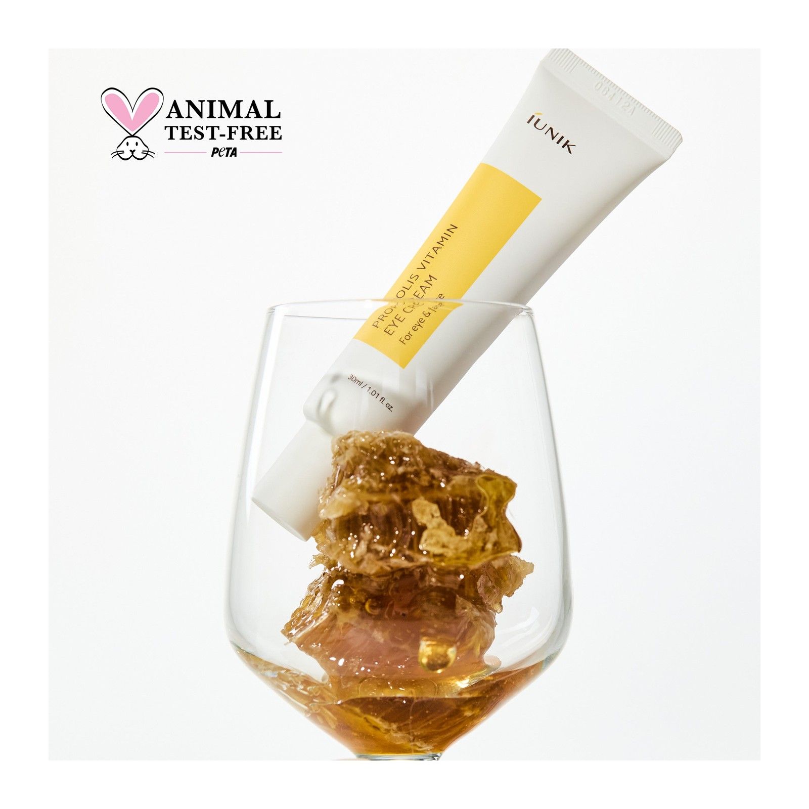 Tubo iUNIK Propolis Vitamin Eye Cream in bicchiere con favo e miele. Sigillo PETA.