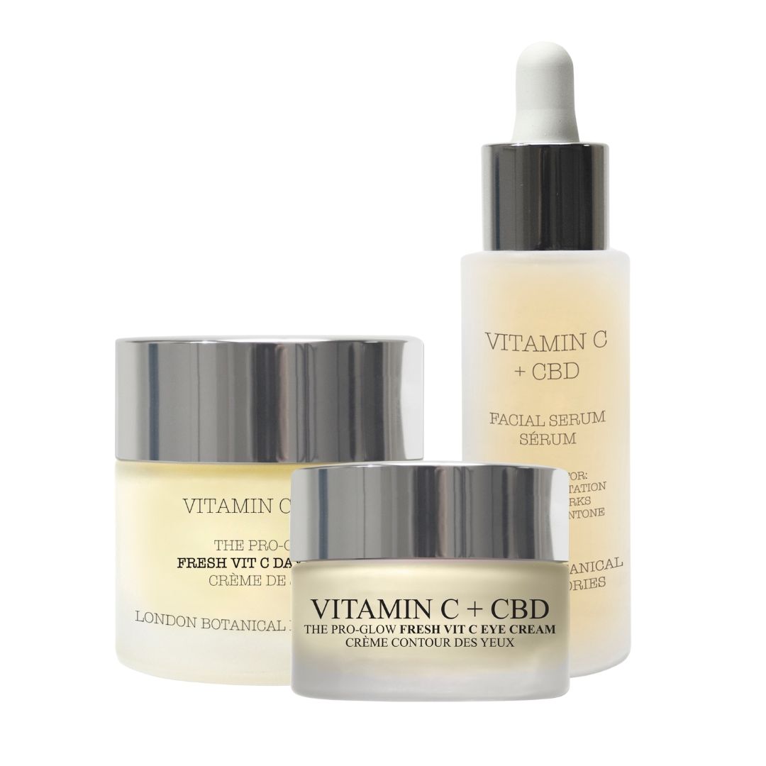 Tre prodotti cosmetici: crema giorno, crema occhi e siero. Contenitori in vetro con coperchi argentati. Scritta: Vitamin C + CBD.